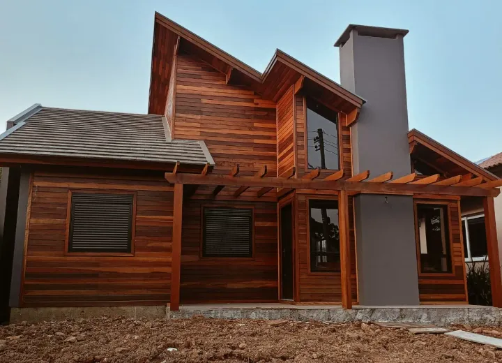 Casa de madeira com volumes marcantes e acabamento natural