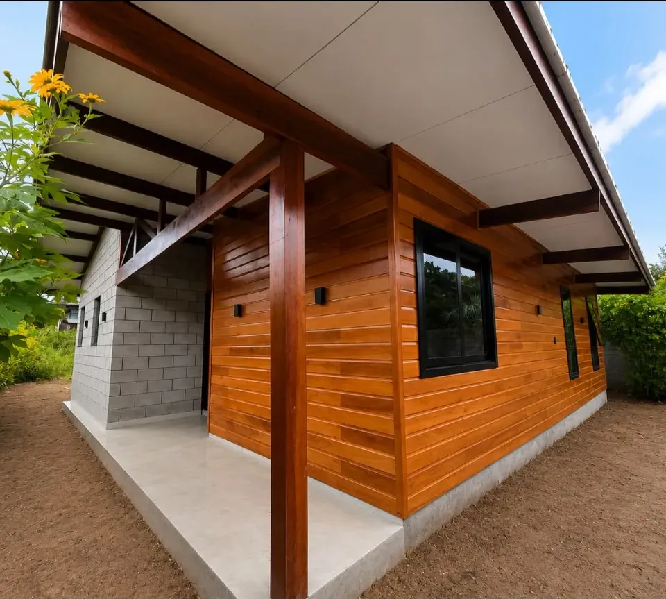 Casa de madeira com varanda, esquadrias escuras e luz natural